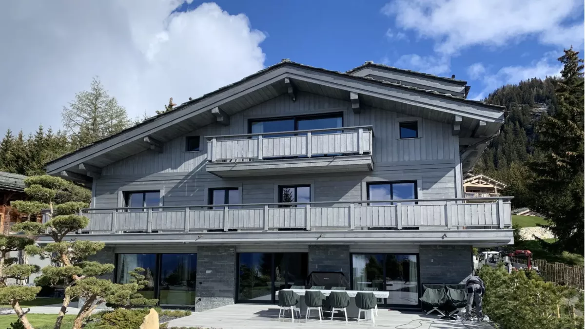 Chalet contemporain en bois à Crans-Montana avec balcons et façade gris clair
