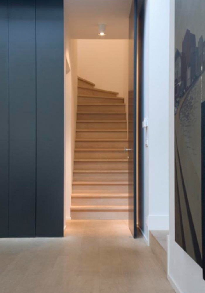 Escalier en bois lumineux dans une entrée moderne à Crans-Montana